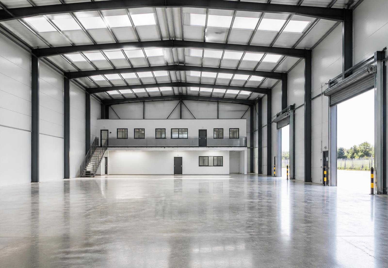 Interior of a completed warehouse with clear-span steel frame and mezzanine office